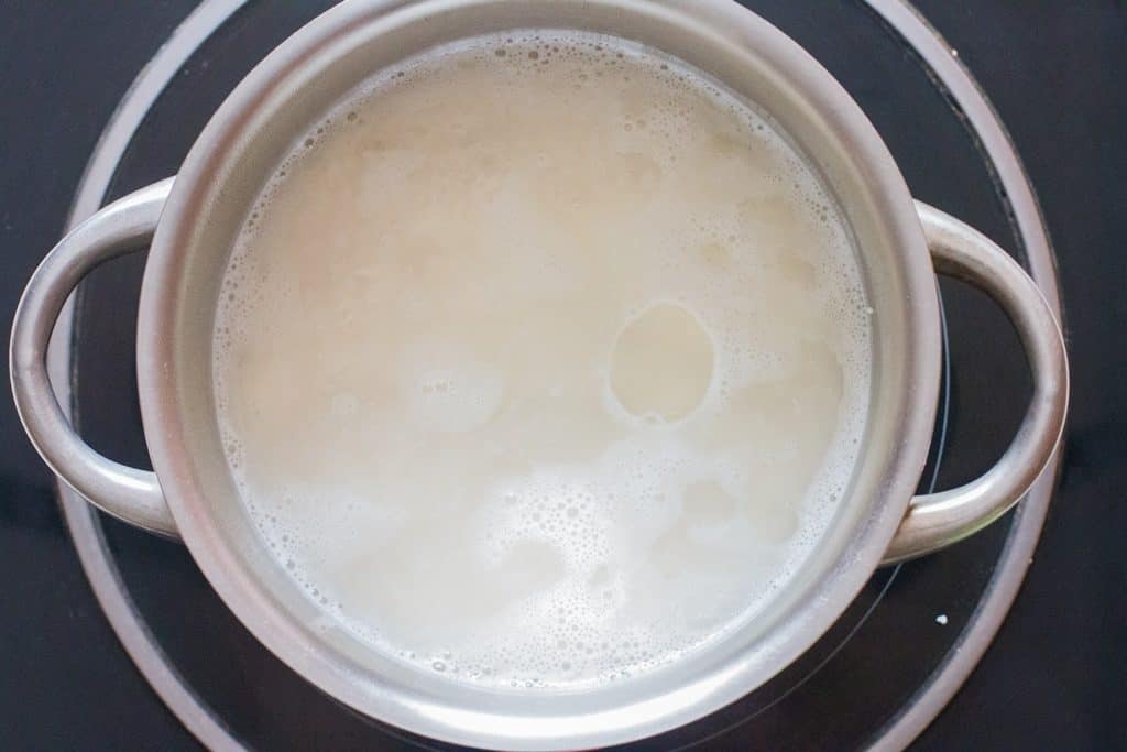 rice and water cooking in a deep-bottomed pan.