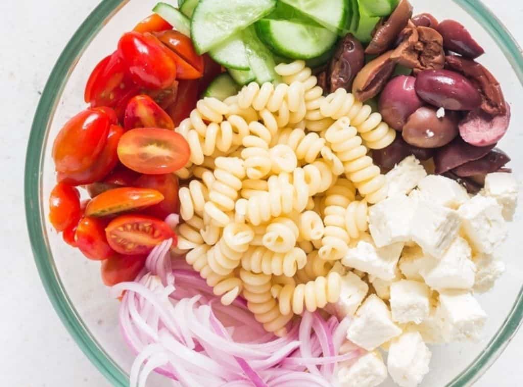 all ingredients for Greek pasta salad in a bowl.