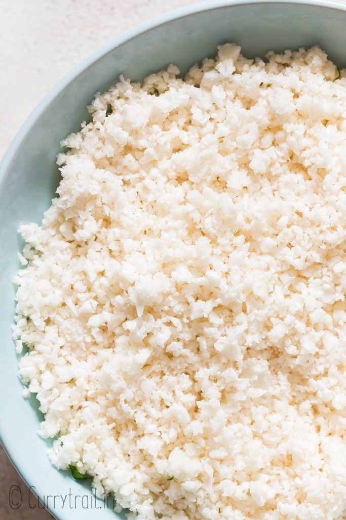 cauliflower rice made in food processor served in blue ceramic bowl