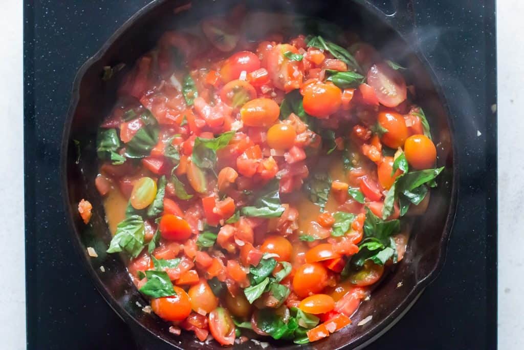 fresh basil leaves added to bruschetta sauce