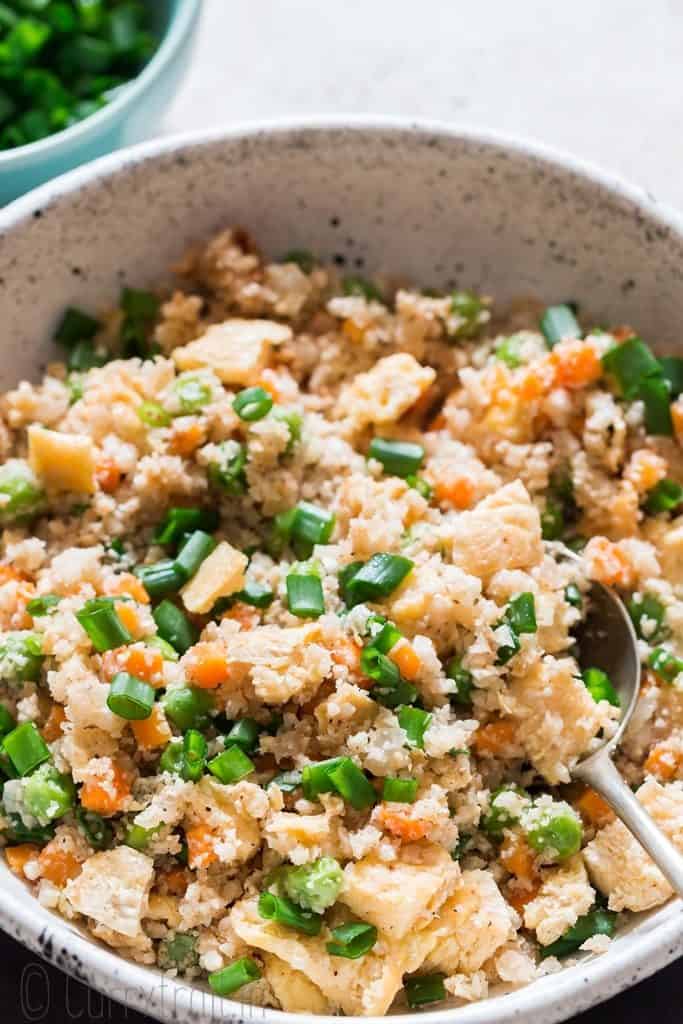 cauliflower fried rice in white bowl with spoon
