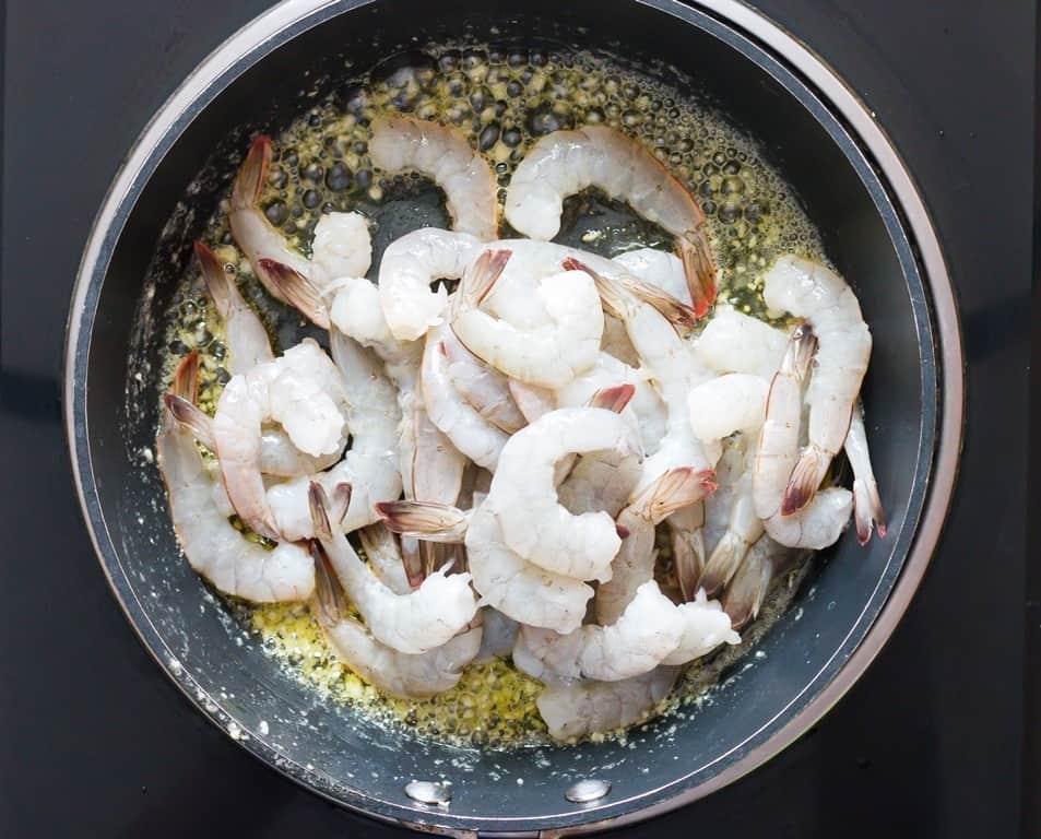 cooking shrimp in a skillet pan with garlic and butter.