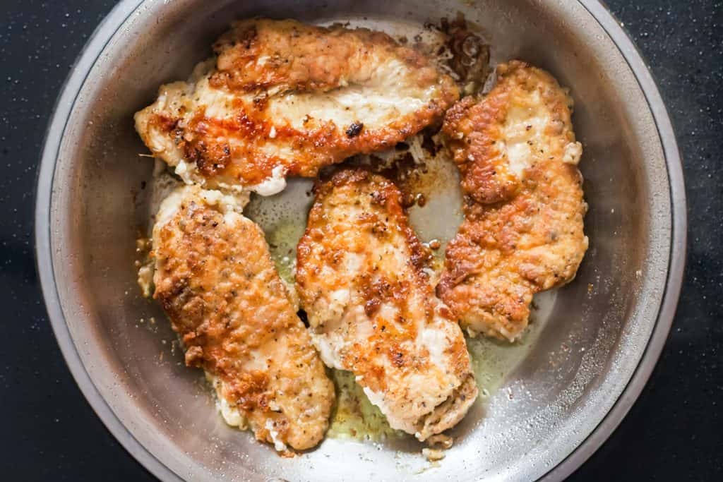 golden lemon pepper chicken cooked in skillet