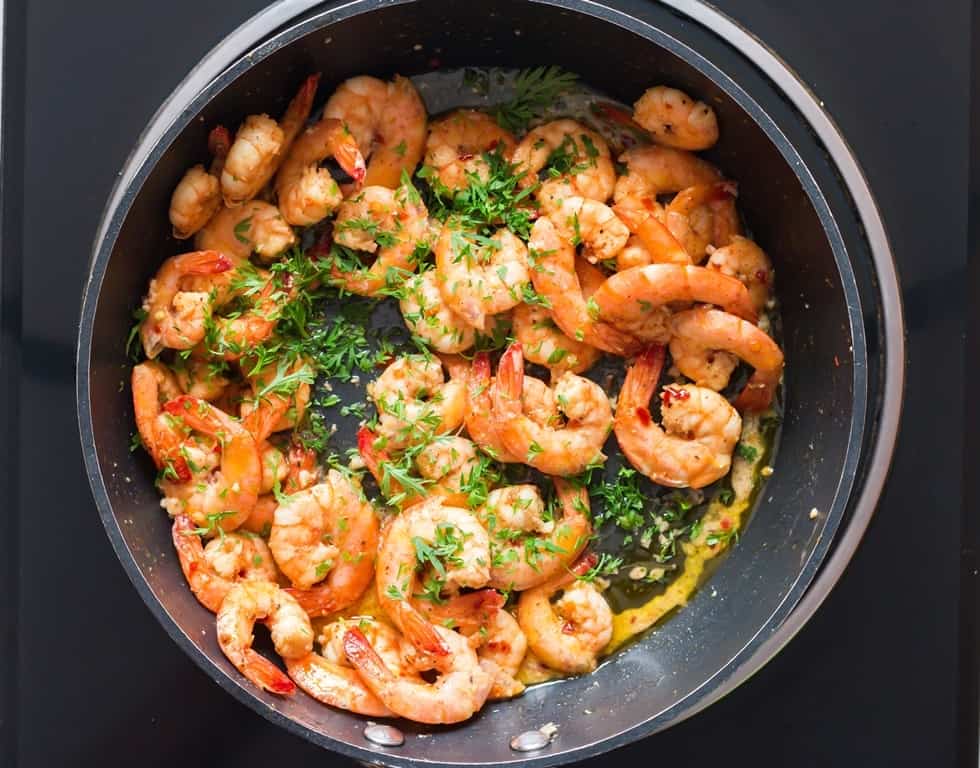 lemon garlic butter shrimp garnished with parsley.