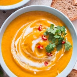 Thai vegan pumpkin curry soup with crusty bread on sides