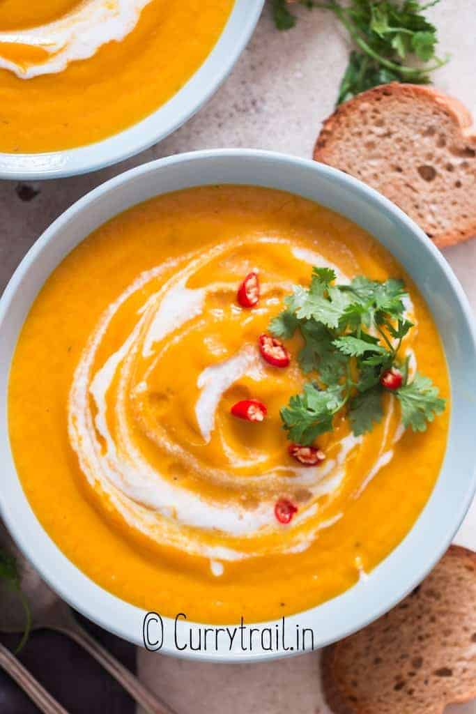 Thai vegan pumpkin curry soup with crusty bread on sides