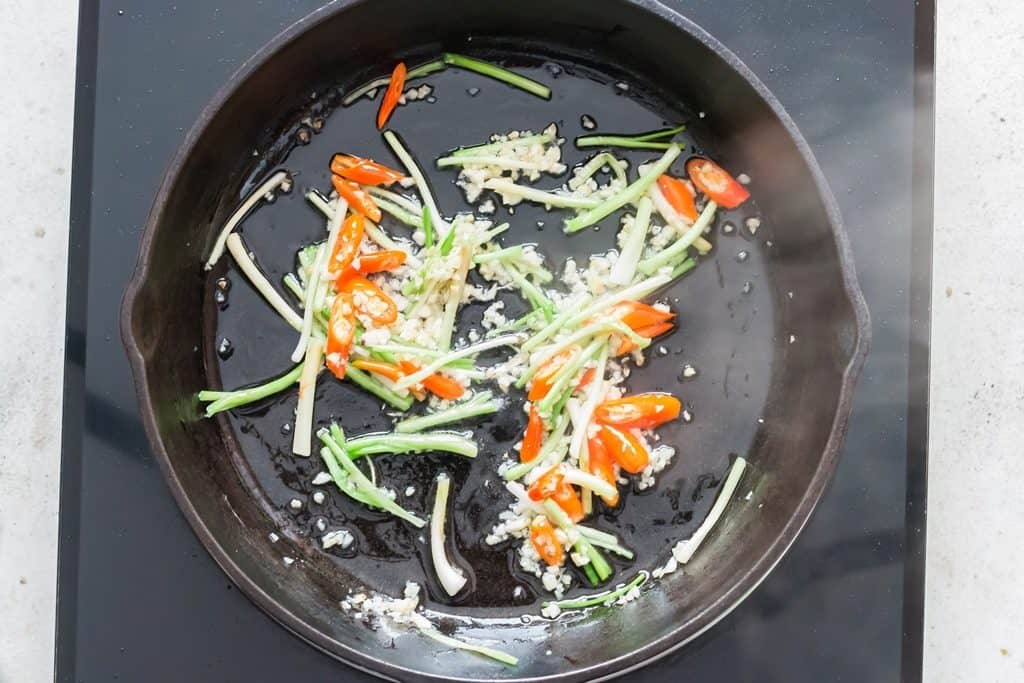 making Thai basil chicken in a pan