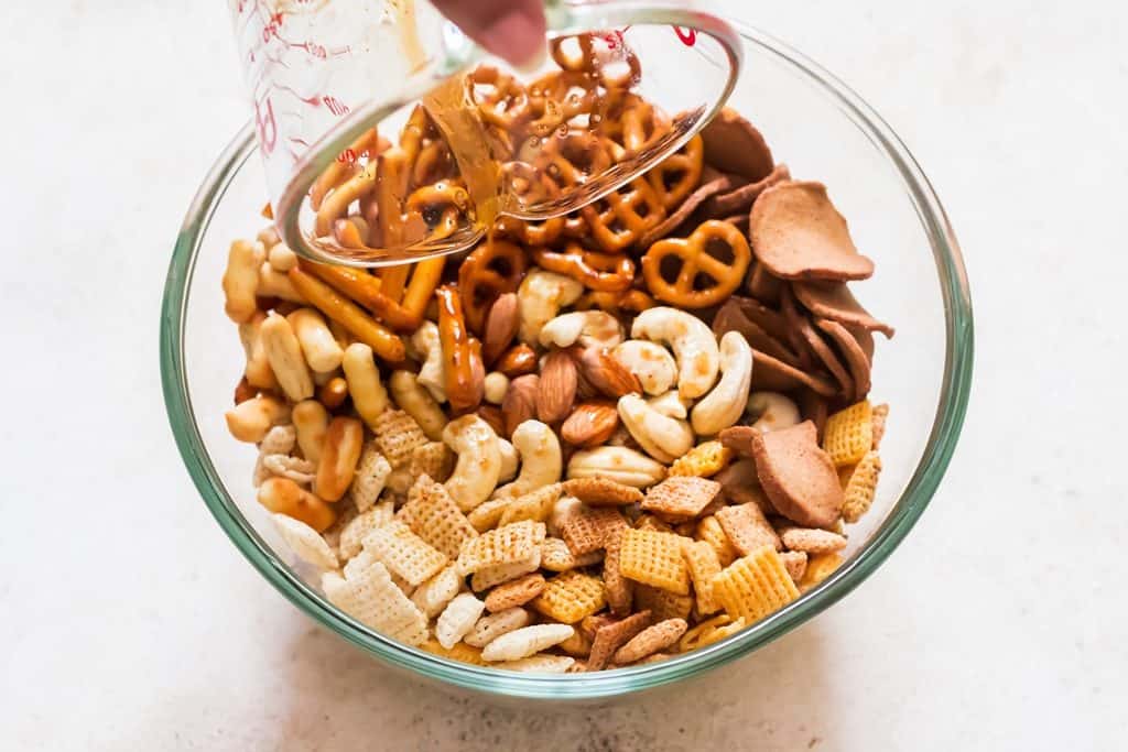 adding seasoning to chex mix bowl