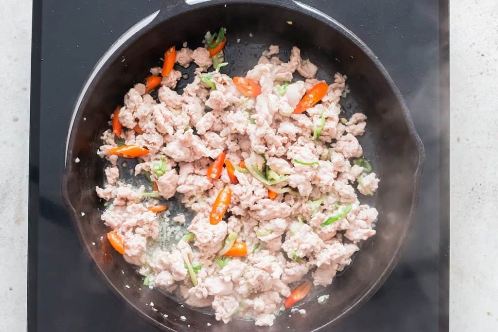 making Thai basil chicken in a pan