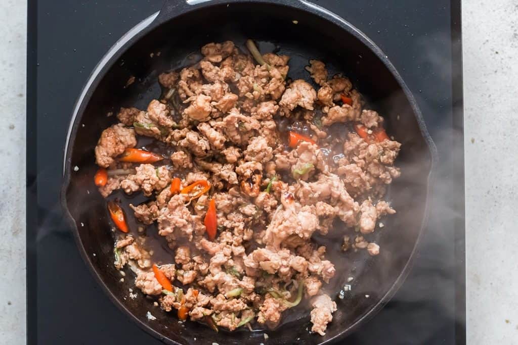 making Thai basil chicken in a pan