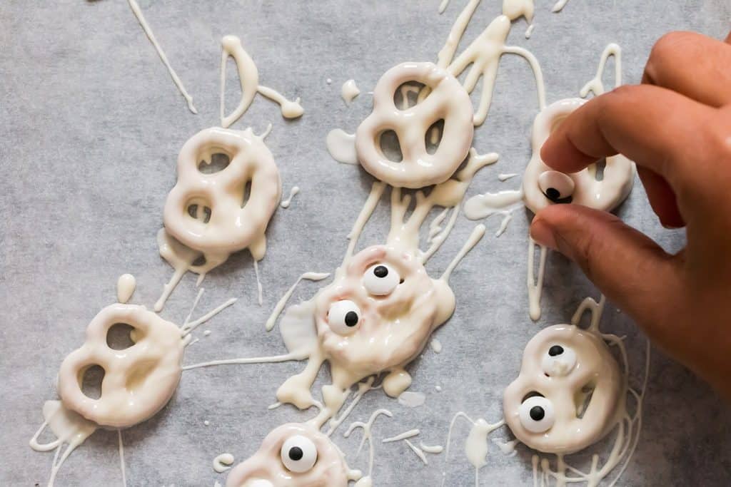 decorating chocolate coated pretzels with eye candy