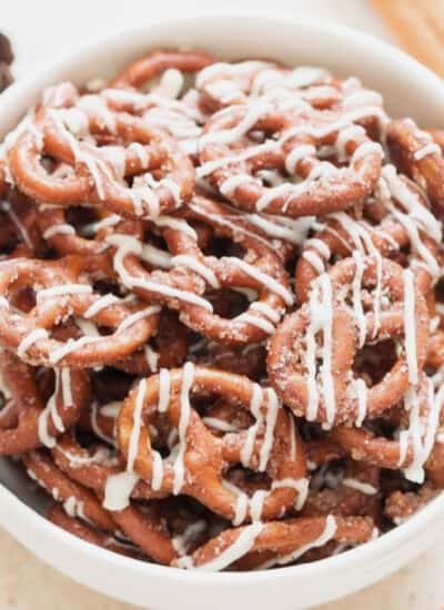 cinnamon sugar pretzels with white chocolate in a white bowl.