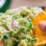 homemade chunky guacamole with nacho chips with text