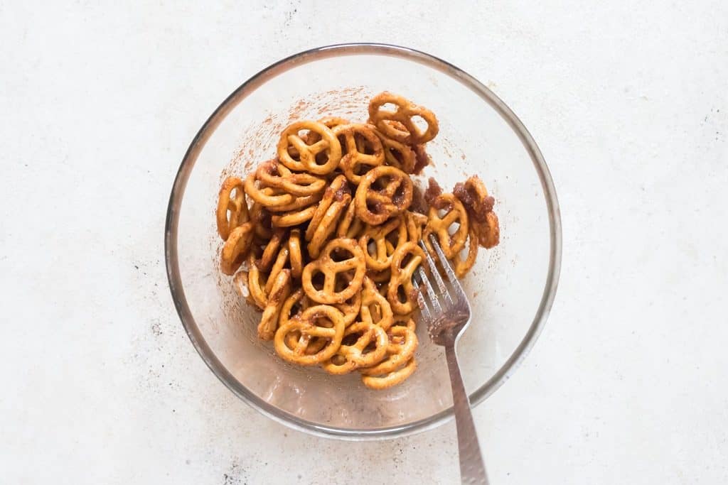coating pretzels twists in cinnamon sugar