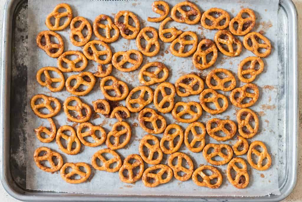 arranging cinnamon-coated pretzels on a baking tray.