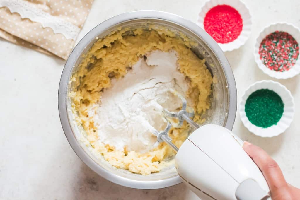 dry ingredients added into bowl of we ingredients for soft sugar cookie recipe