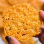 holding a crispy parmesan crisp.