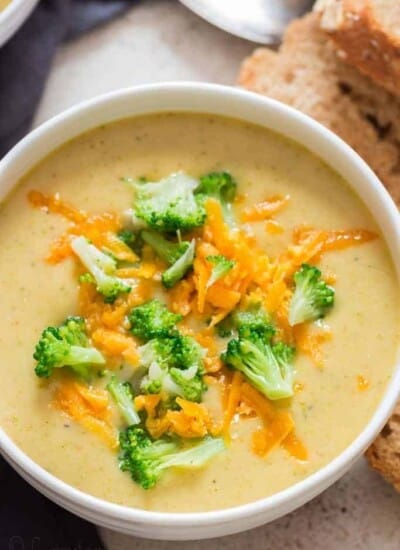 panera copycat broccoli cheddar soup in white bowl crusty bread on side