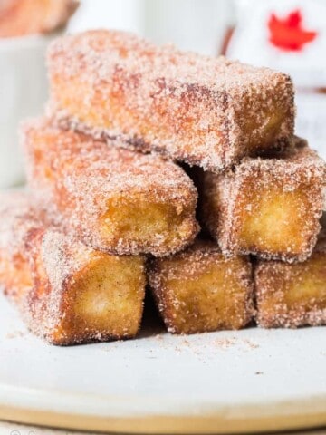 cinnamon french toast stick stacked on white plate