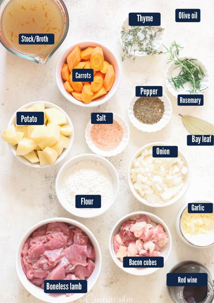all the ingredients for the lamb stew recipe on a table.