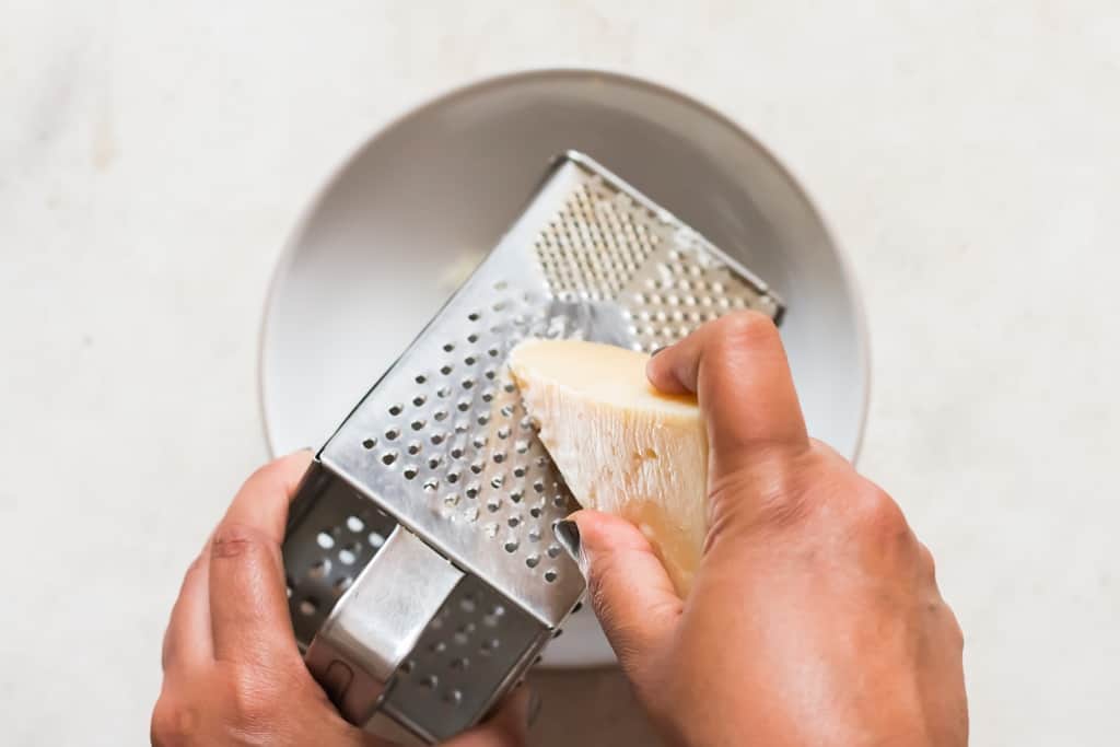 grating a block of parmesan cheese