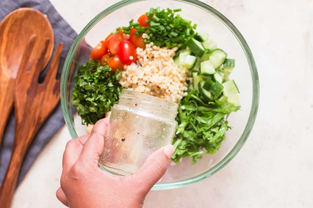 pour lemon salad dressing over salad bowl