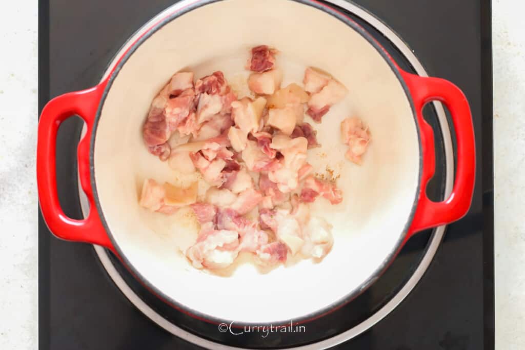 browning thick bacon cubes in a Dutch oven.