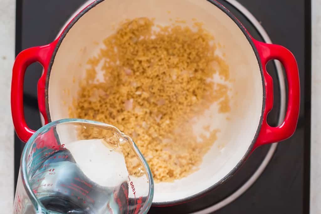 cooking pearl couscous in water in the cooking pot.