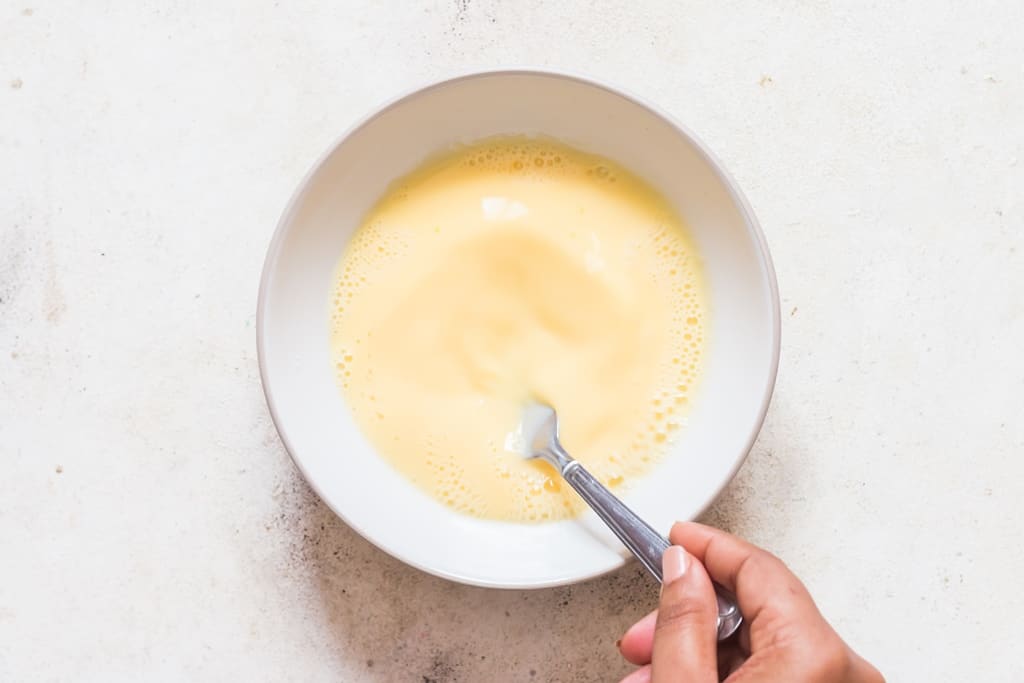 whisking egg custard mix in bowl