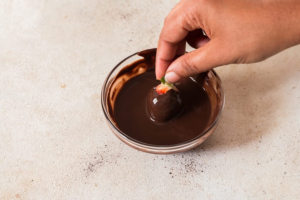 dipping strawberries in melted chocolate.