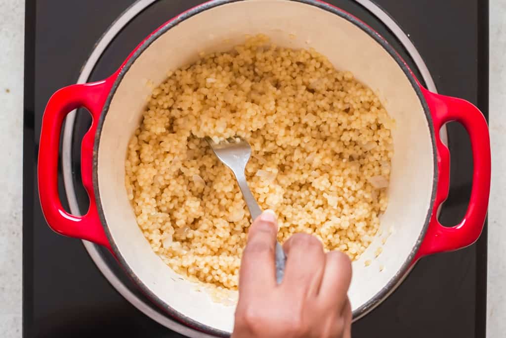 fluff cooked couscous with a fork.