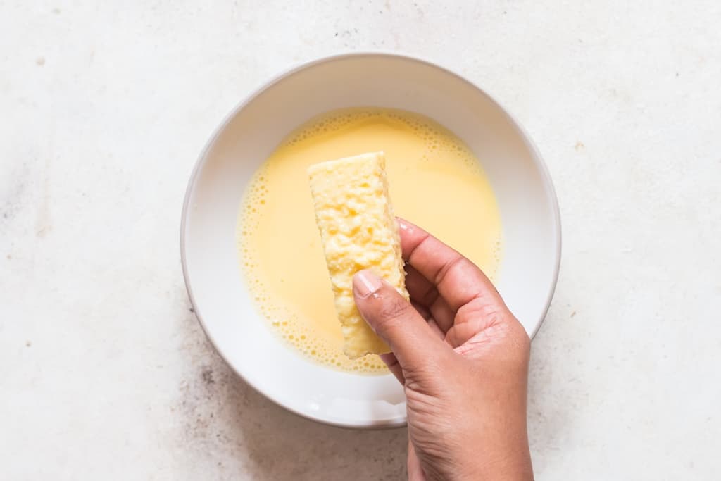 shaking off excess egg mixture off bread sticks