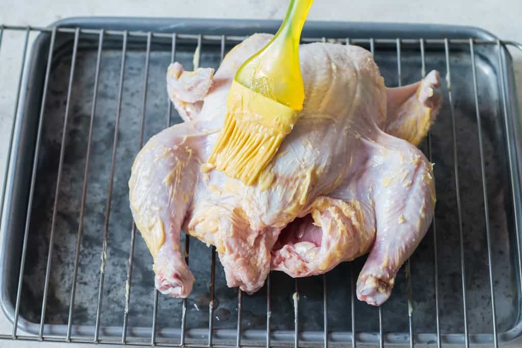 rubbing butter over chicken before roasting