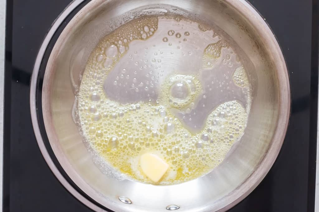 melting butter in skillet to fry French toast sticks