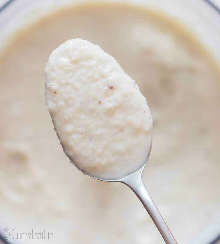 creamy cauliflower cheese sauce in a spoon