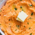 sweet potato mash served with cubes of butter in white bowl