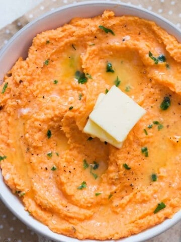 sweet potato mash served with cubes of butter in white bowl