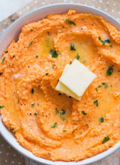 sweet potato mash served with cubes of butter in white bowl