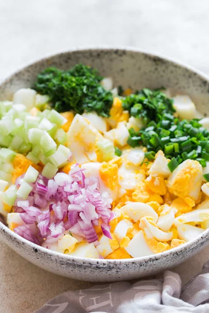 classic egg salad ingredients in white bowl