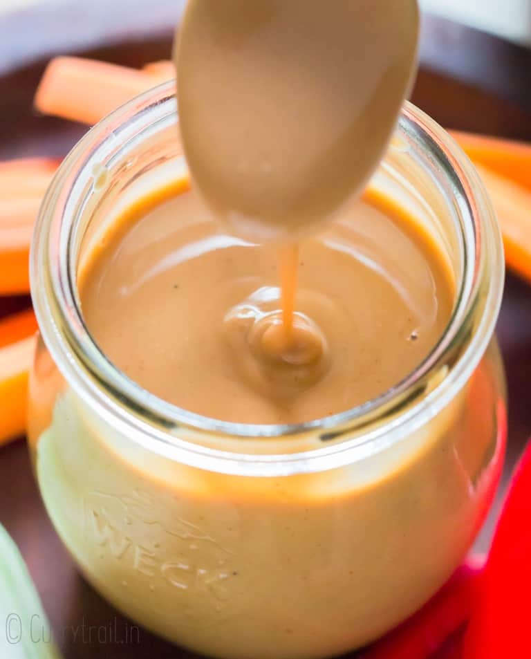 peanut sauce poured with a spoon in glass jar