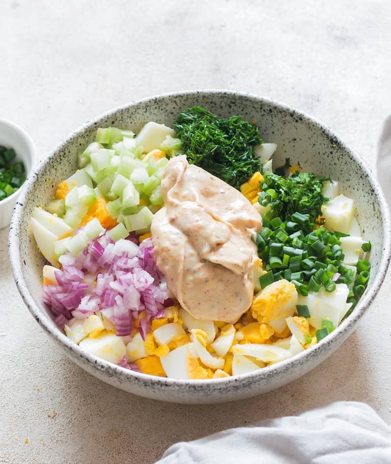 classic egg salad with dressing mixed in white bowl