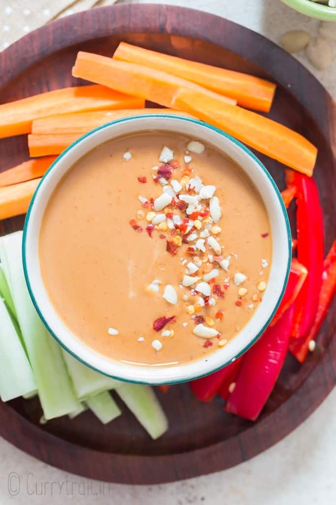 best ever peanut sauce served with raw vegetables on wooden plate