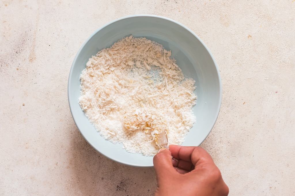 coating shrimps in shredded panko mix.