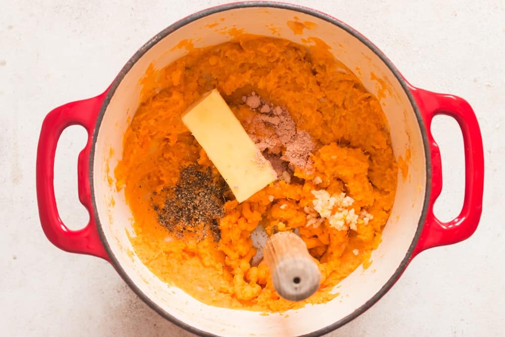 butter and seasoning added to mashed sweet potatoes