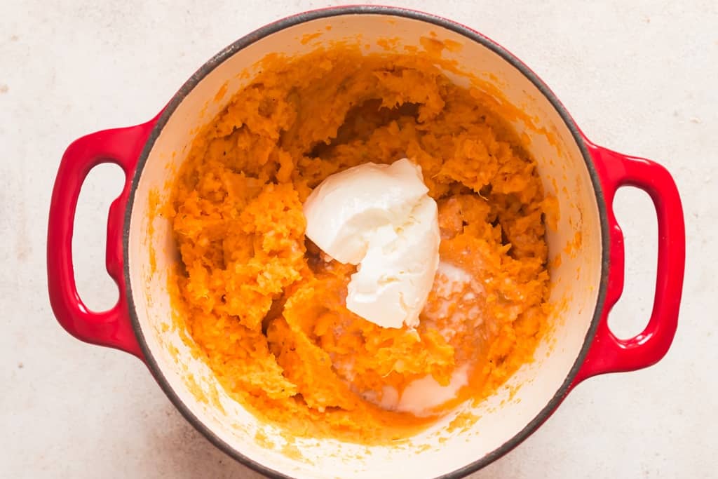 sour cream added to the pot of mashed sweet potatoes