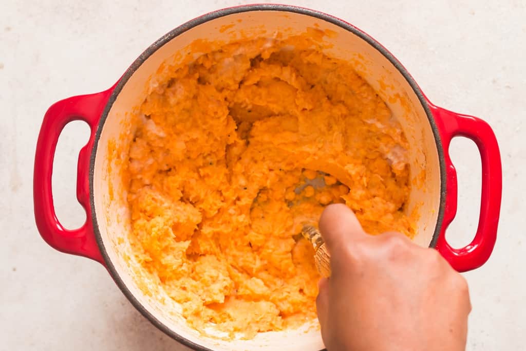 mashed sweet potatoes mashed with hand masher ready to be served as side dish
