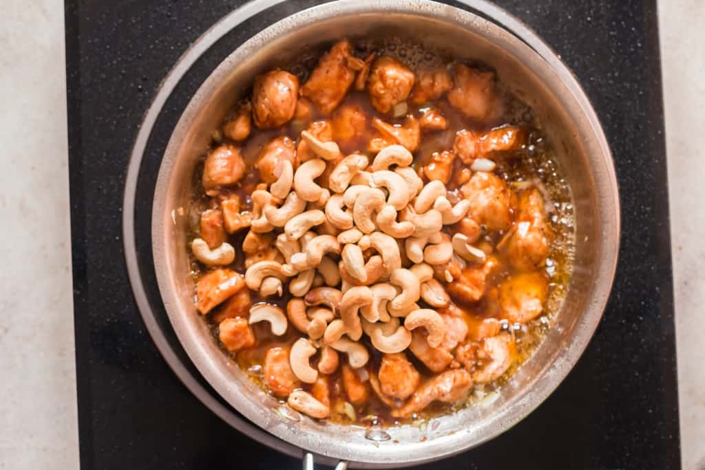 cashews and chicken cookign in skillet