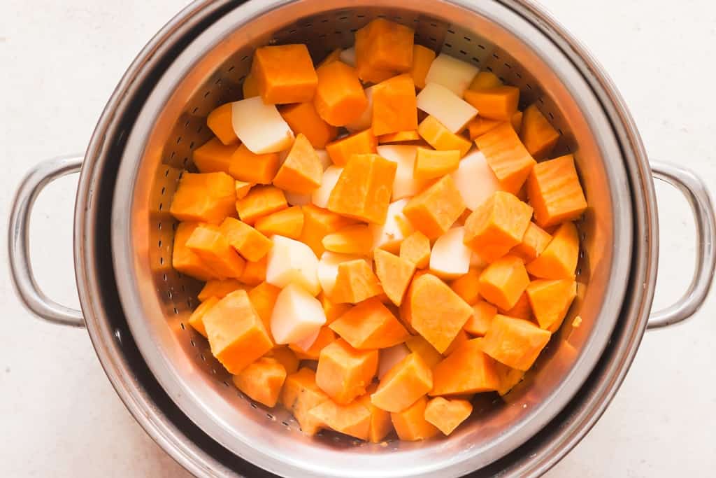 cooked sweet potatoes drained in colander ready to be mashed