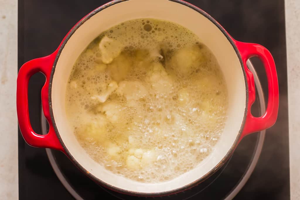 cooking cauliflower florest in vegetable broth in a stock pot until it's tender