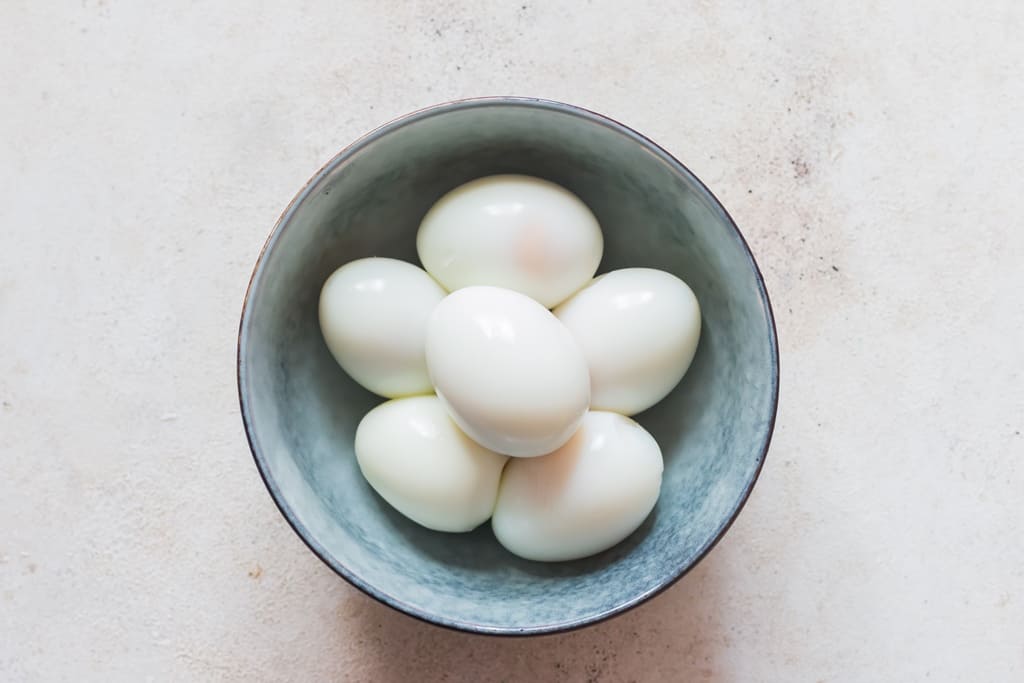 eggshells peeled from hard-boiled eggs in a bowl.